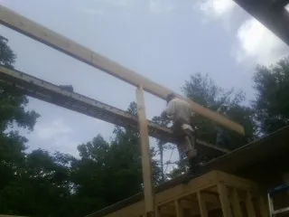 Carpenter setting a ridge beam over a new addition frame — Ice Dam Removal by Roofing Brothers in Big Cove Tannery
