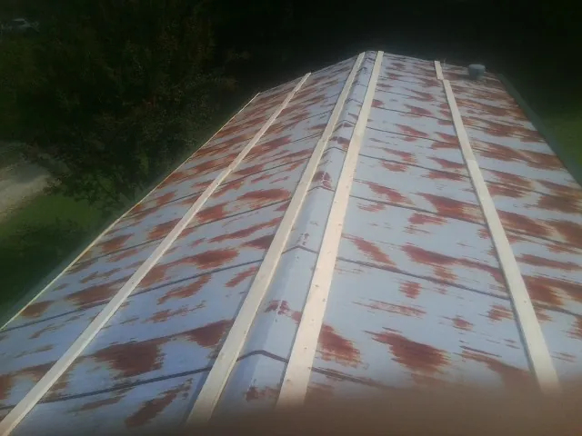 Rusted metal roof panels with new wood purlins before replacement — Storm Damage Roof Repair in Big Cove Tannery by Roofing Brothers