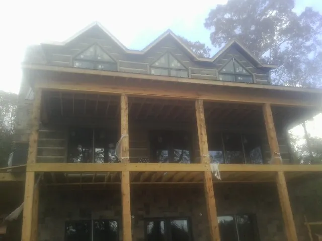 Dormers and porch framing on a large log home under construction — Roof Coating work by our crew in Big Cove Tannery