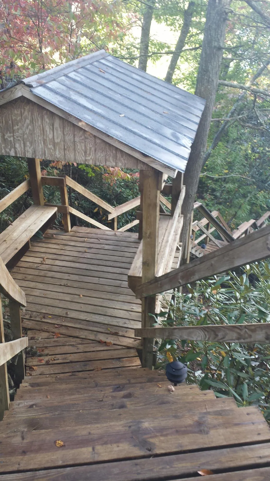 Metal roofed shelter over wooden steps on a wooded walkway — Skylight Repair & Installation work by our crew in Big Cove Tannery
