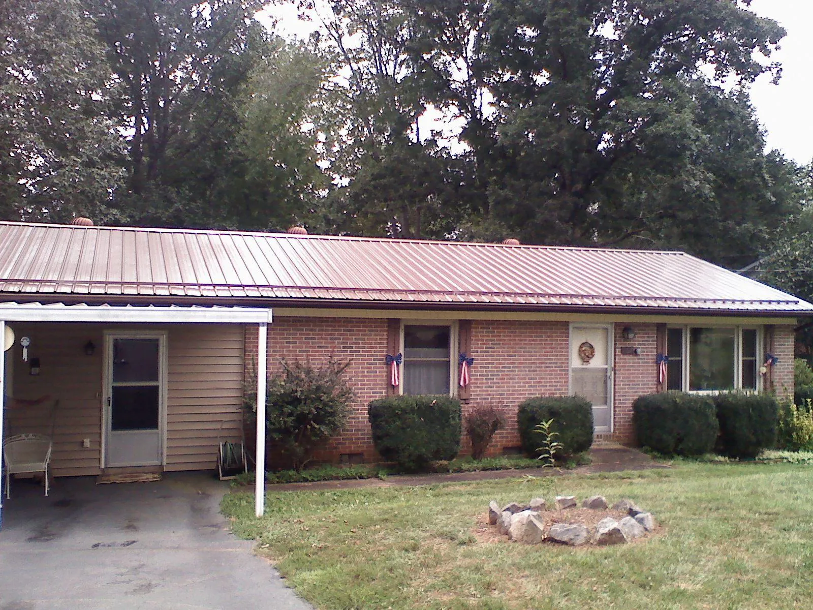 Bronze metal roof and carport on a brick ranch home — Roof Repair work by our crew in Big Cove Tannery